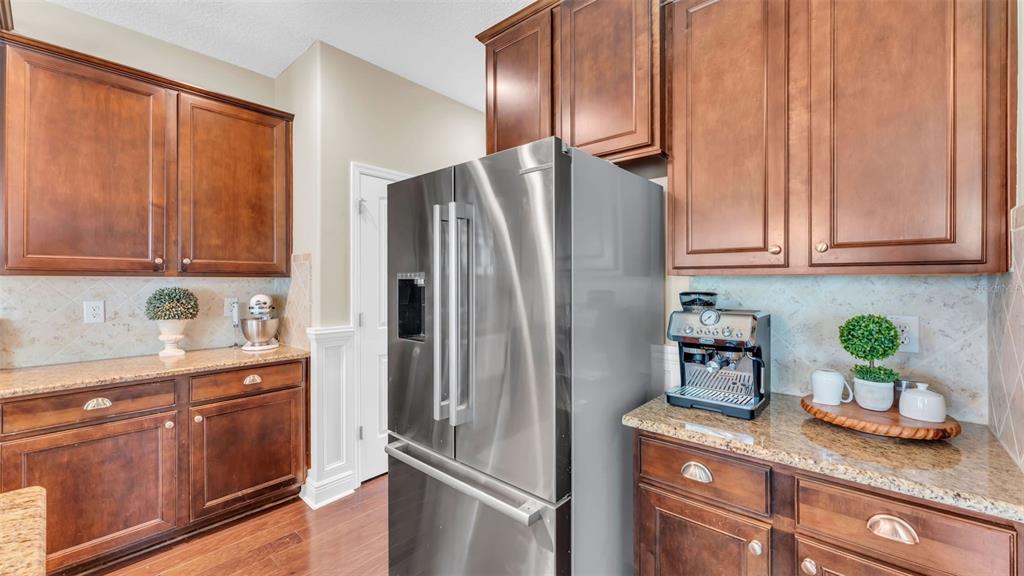 132 Magneta Loop Auburndale, FL 33823 - Photo 11 of 56 a kitchen with granite countertop stainless steel appliances a refrigerator a sink a stove and cabinets