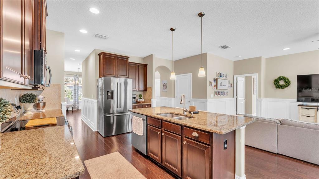 132 Magneta Loop Auburndale, FL 33823 - Photo 12 of 56 a kitchen with stainless steel appliances granite countertop a refrigerator a sink and a stove