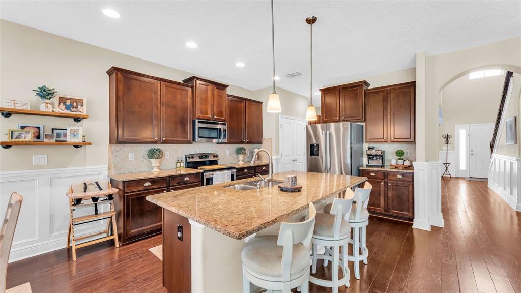 132 Magneta Loop Auburndale, FL 33823 - Photo 13 of 56 a kitchen with granite countertop a table chairs microwave and cabinets