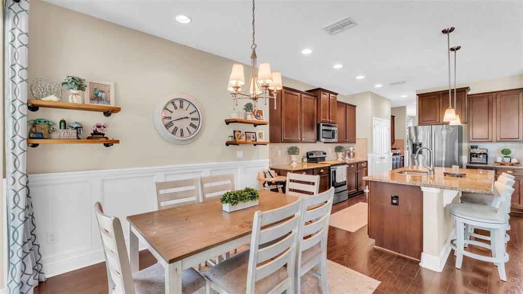 132 Magneta Loop Auburndale, FL 33823 - Photo 16 of 56 a kitchen with stainless steel appliances kitchen island granite countertop a table chairs cabinets and wooden floor