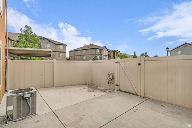 656 South 910 West, Unit 25 Pleasant Grove, UT 84062 - Photo 23 of 25 Private patio area featuring concrete flooring and a light-toned privacy fence, creating a clean and low-maintenance outdoor space.