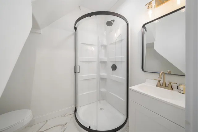 a bathroom with a bathtub shower sink vanity and toilet