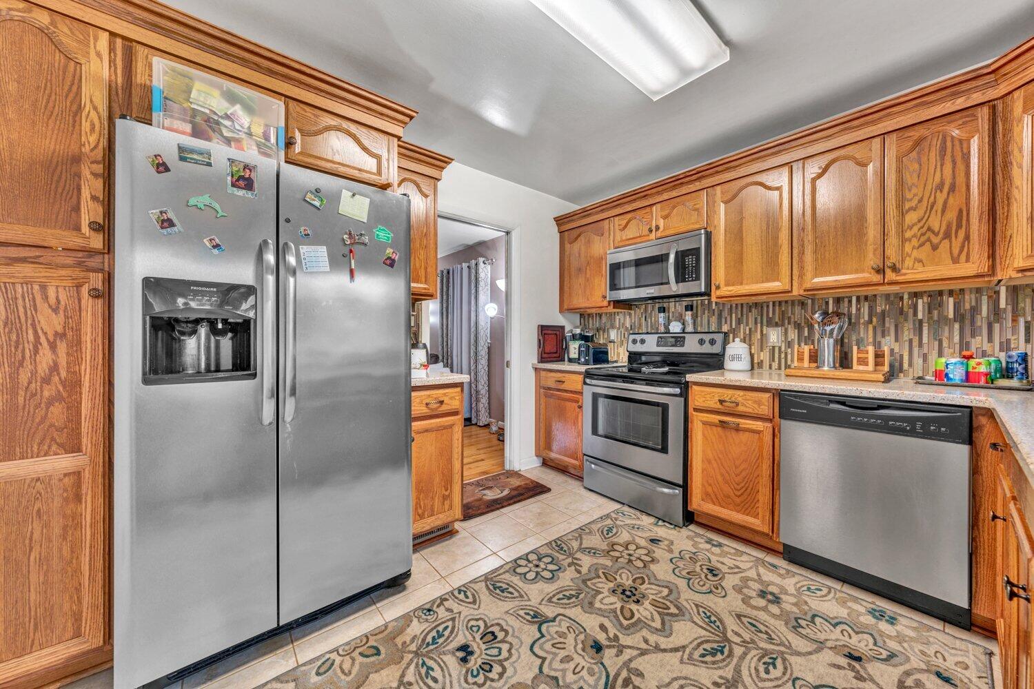 3131 Galloway Drive Roanoke, VA 24018 - Photo 9 of 37 a kitchen with granite countertop a refrigerator and a stove top oven