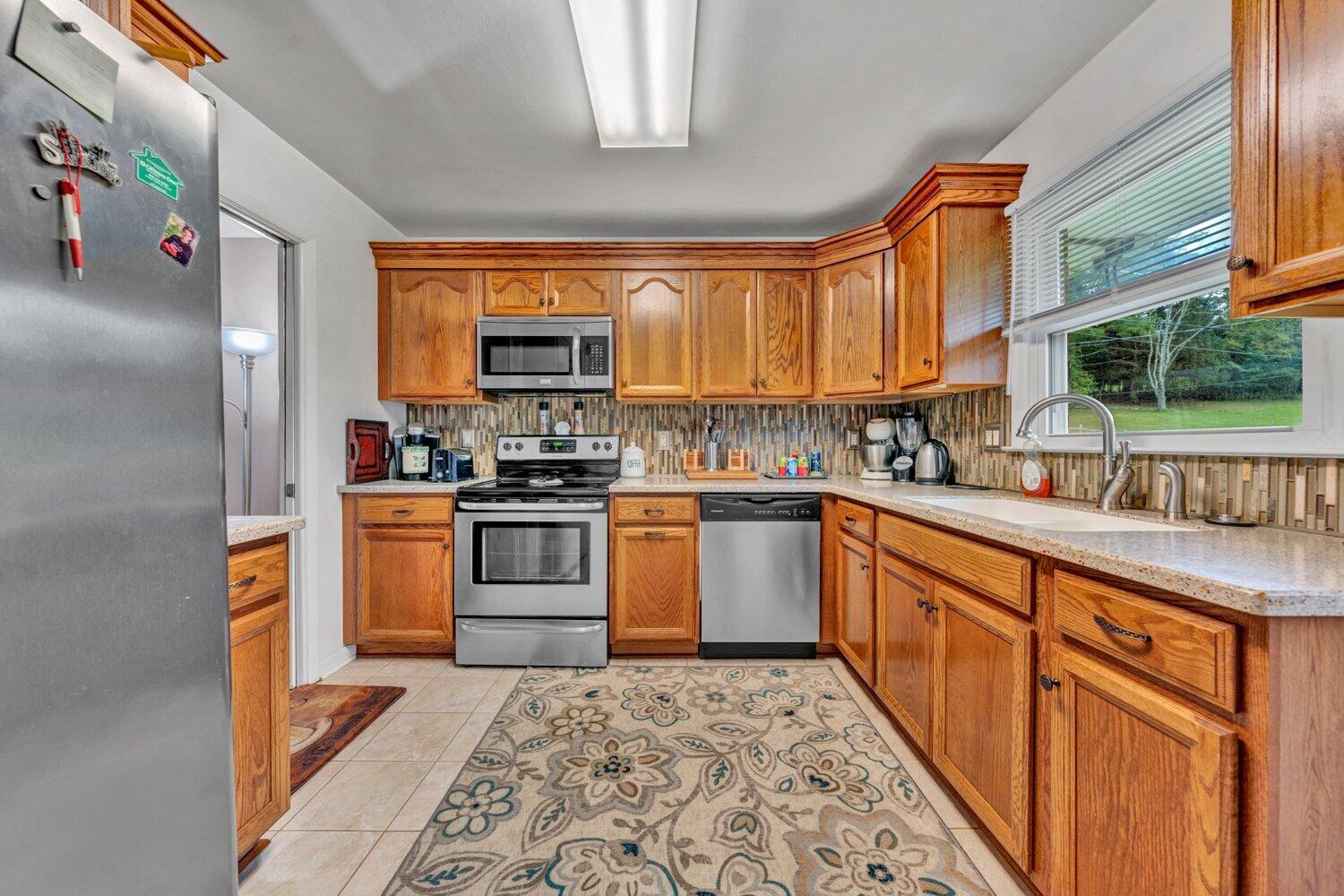 3131 Galloway Drive Roanoke, VA 24018 - Photo 10 of 37 a kitchen with stainless steel appliances granite countertop a stove a sink and a refrigerator