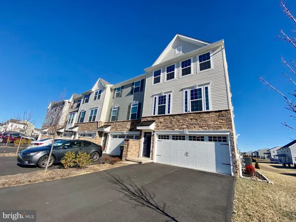 a front view of a house with cars parked