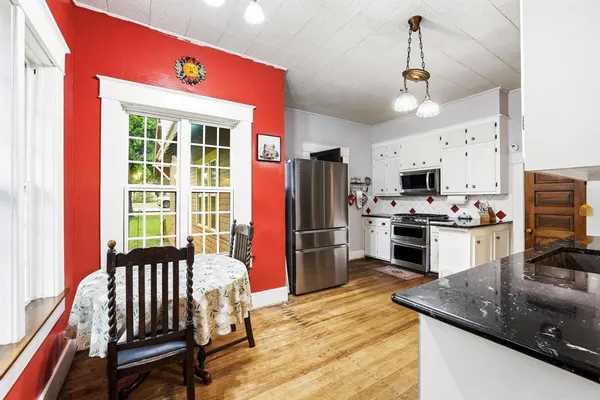 a kitchen with granite countertop a stove a sink and a refrigerator
