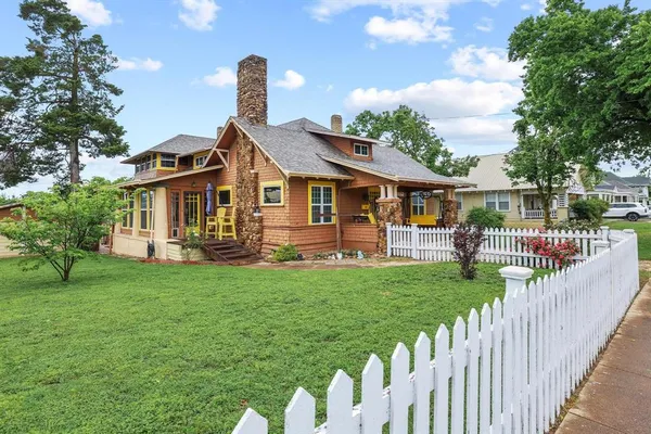a front view of a house with yard and furniture