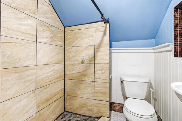 a bathroom with a toilet and a shower