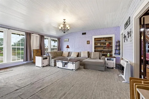 a living room with furniture large window and flat screen tv