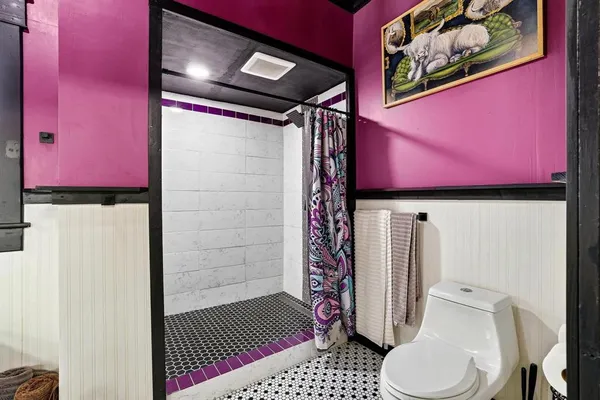 a bathroom with a toilet and a shower curtain