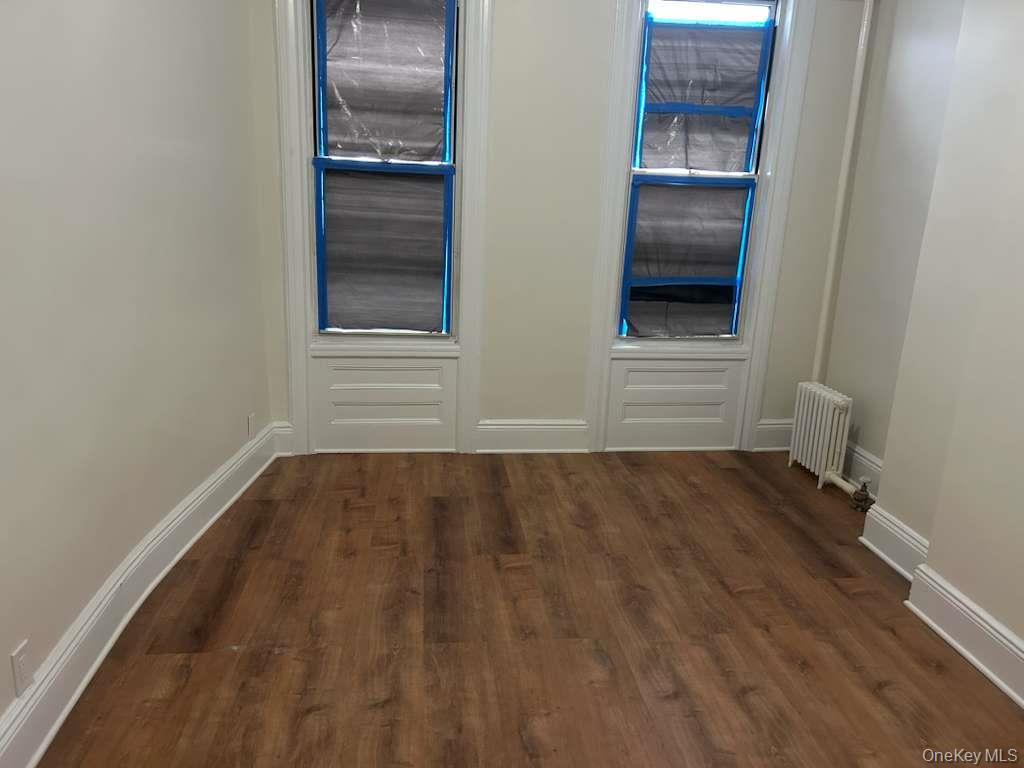 88-23 85th Street, Unit 1L Queens, NY 11421 - Photo 13 of 17 a view of an empty room with wooden floor and a window