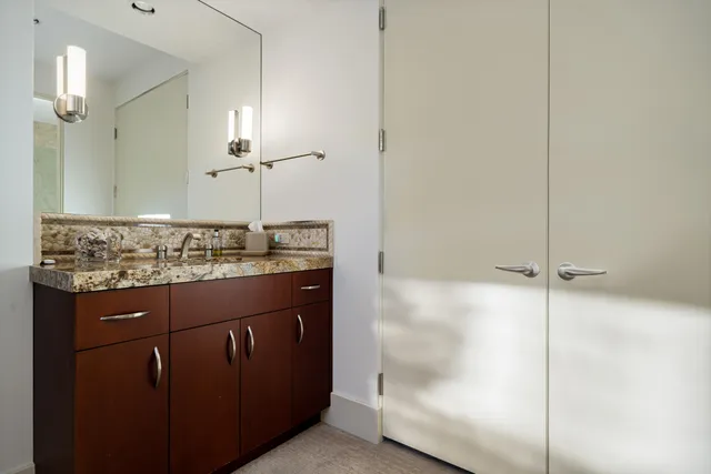 a bathroom with a granite countertop sink and a mirror