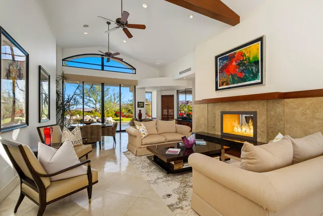 a living room with furniture a fireplace and a chandelier