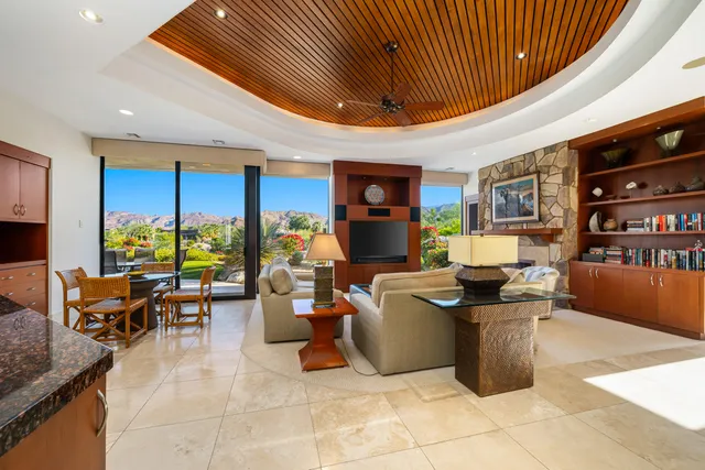 a living room with furniture a flat screen tv and a dining table