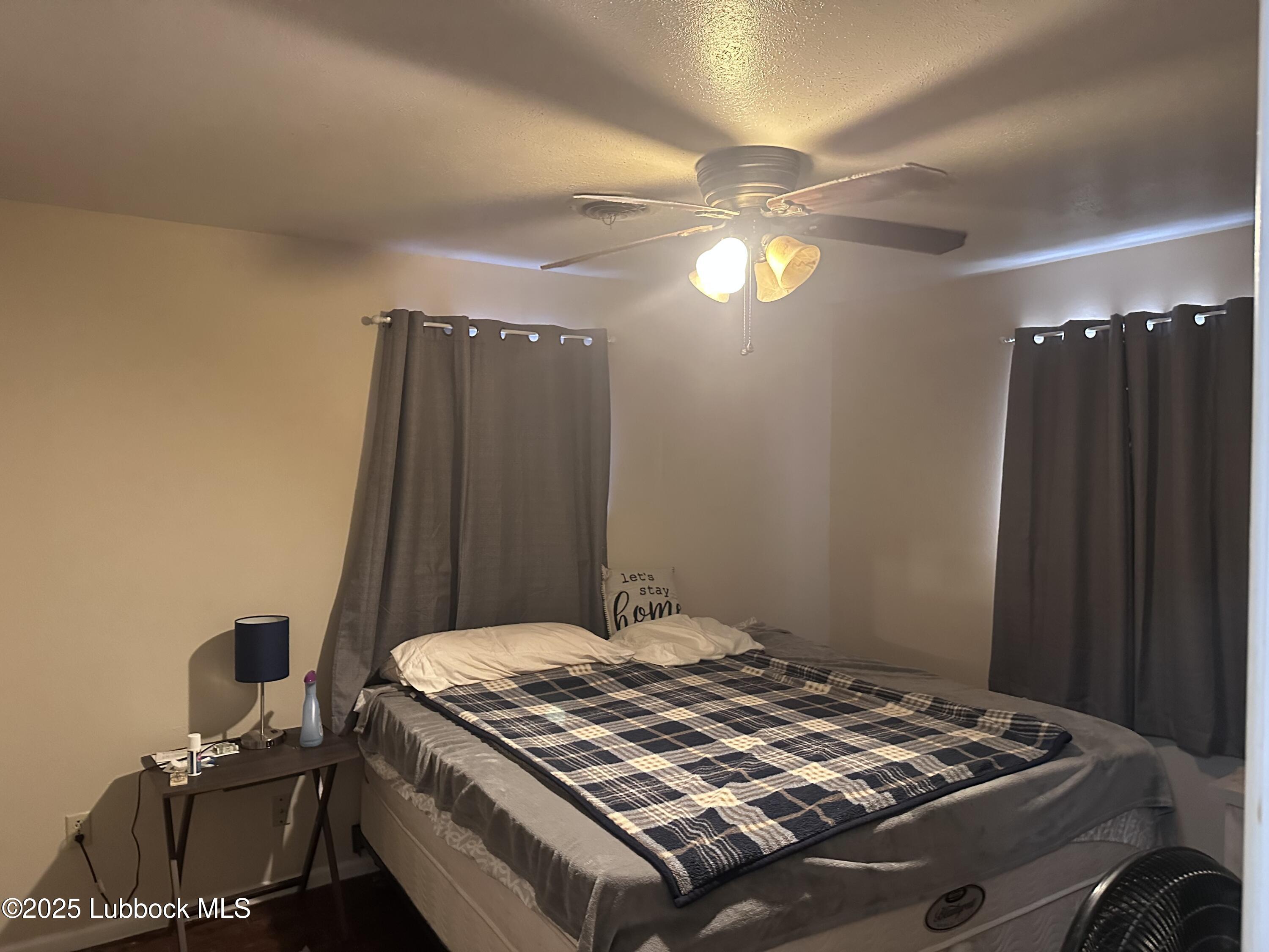5202 41st Street Lubbock, TX 79414 - Photo 12 of 18 a bedroom with a bed and a chandelier