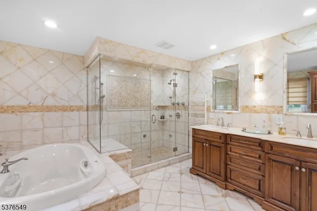 a bathroom with a tub sink mirror and shower