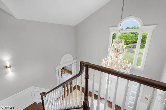 a view of a hallway with wooden staircase and stairs