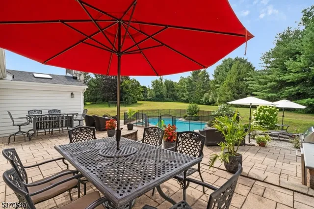 a view of a patio with a table and chairs under an umbrella