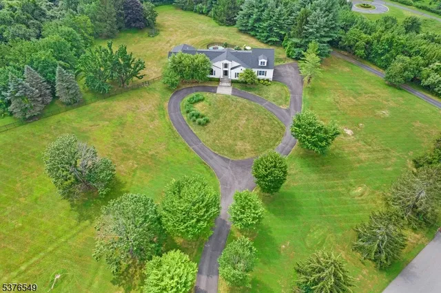 an aerial view of residential house with outdoor space and trees all around