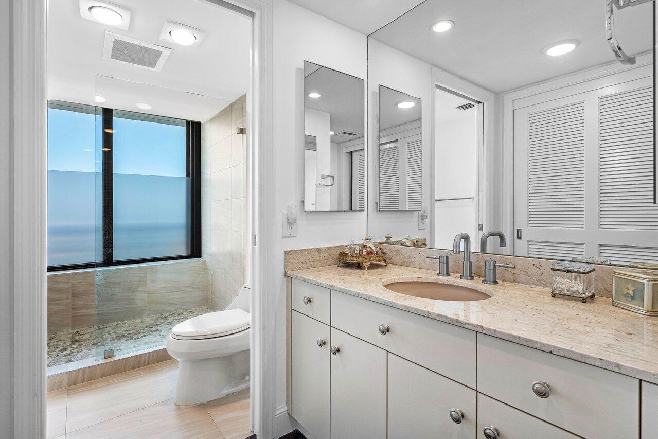 1500 South Ocean Boulevard, Unit 804 Boca Raton, FL 33432 - Photo 11 of 45 a bathroom with a granite countertop sink a toilet and a shower