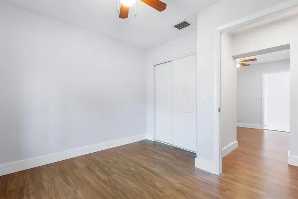 a view of an empty room with wooden floor