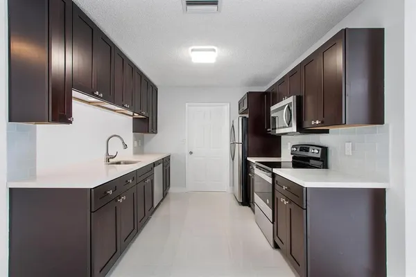 a kitchen with stainless steel appliances granite countertop a sink stove and refrigerator