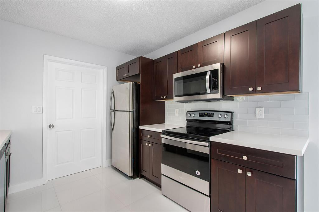 9611 Saddlebrook Drive Boca Raton, FL 33496 - Photo 5 of 15 a kitchen with a refrigerator stove and microwave