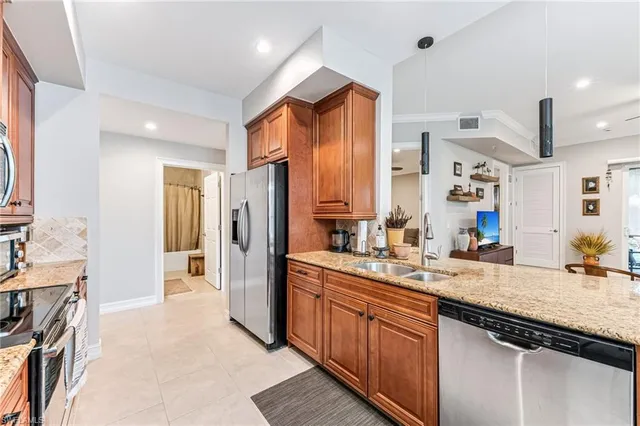 a kitchen with stainless steel appliances granite countertop a refrigerator and a stove top oven