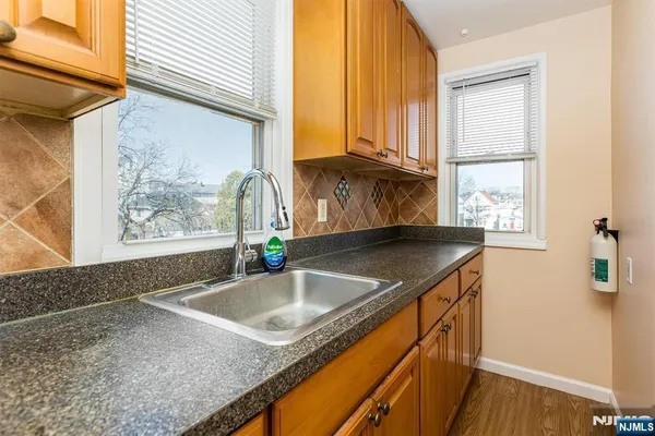 a bathroom with a granite countertop sink and a window