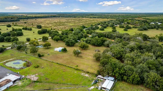 an aerial view of a pool with a yard