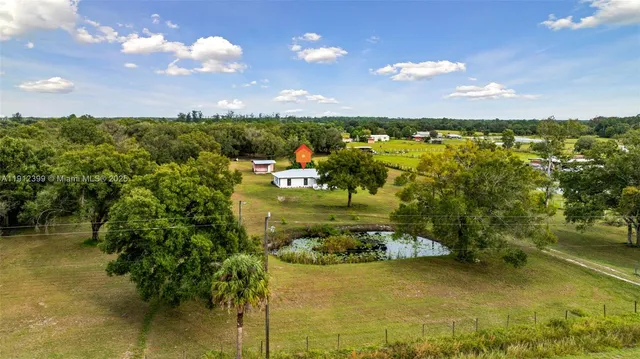a open kitchen with granite countertop a stove a sink and white cabinets with wooden floor