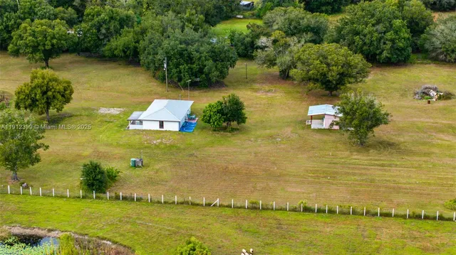 an aerial view of residential houses with outdoor space and swimming pool