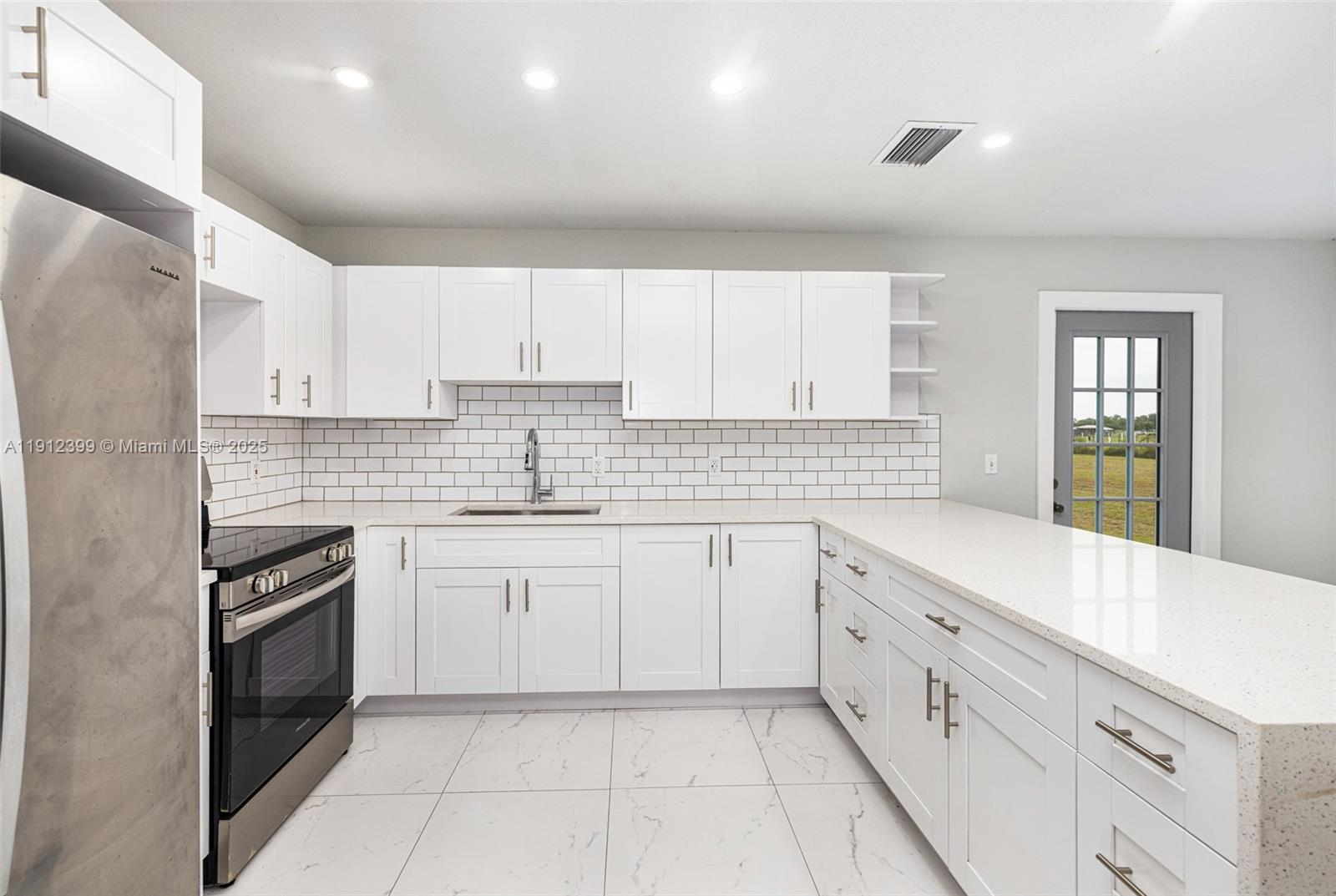 2404 Silver Lake Road LaBelle, FL 33935 - Photo 62 of 89 a kitchen with granite countertop white cabinets white stainless steel appliances with a sink and dishwasher