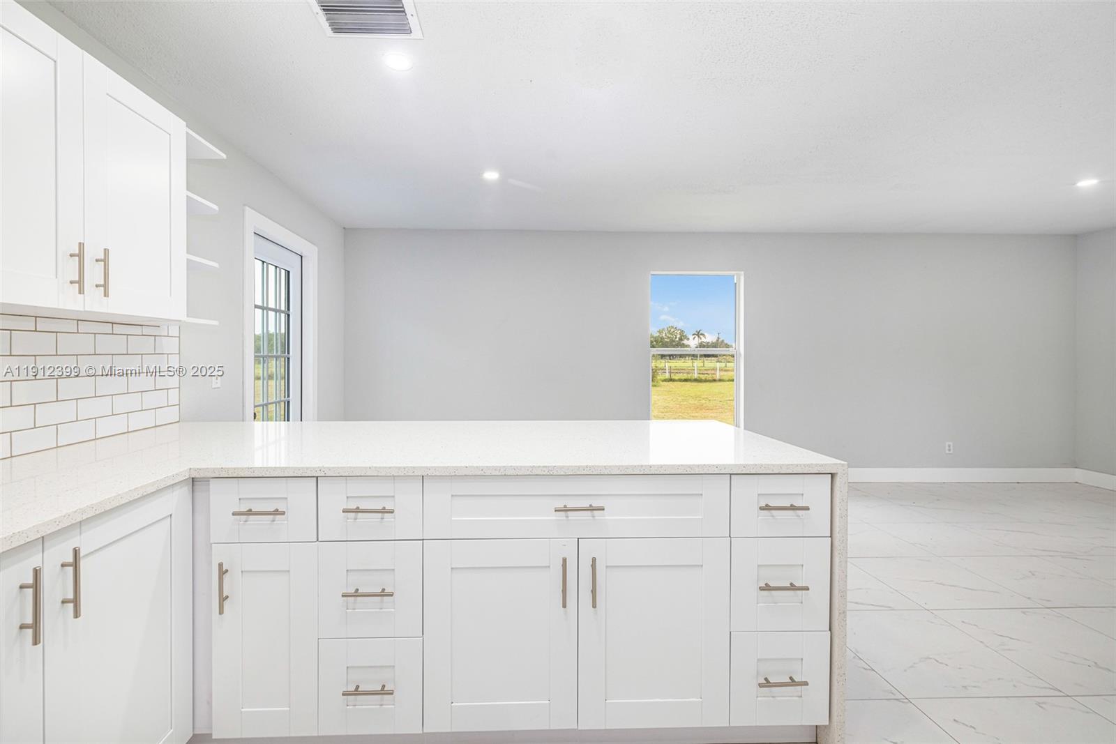 2404 Silver Lake Road LaBelle, FL 33935 - Photo 65 of 89 a kitchen with white cabinets and window
