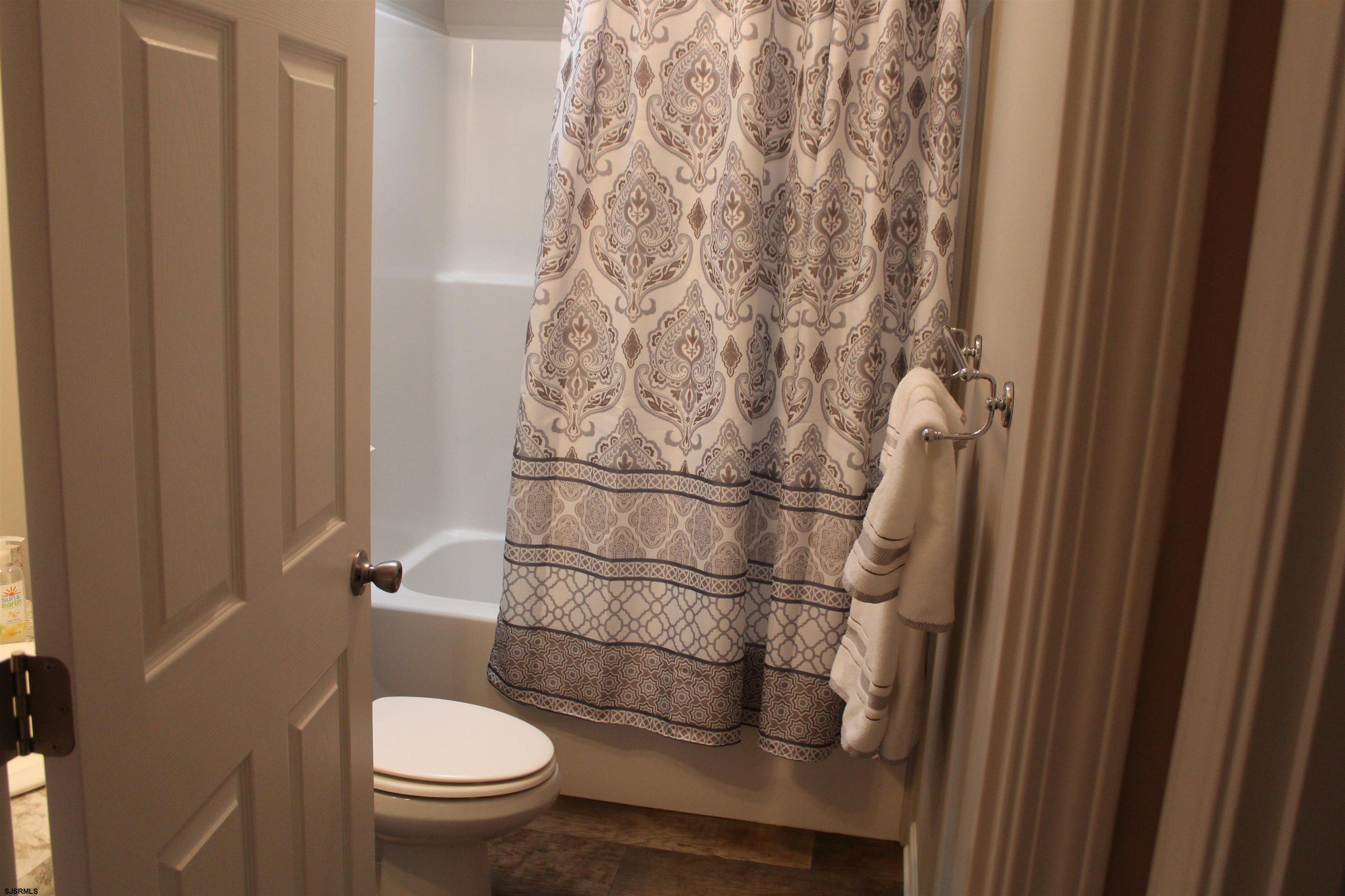 2058 South Shore Road, Unit 210 Ocean View, NJ 08230 - Photo 11 of 17 a bathroom with a toilet and a shower curtain