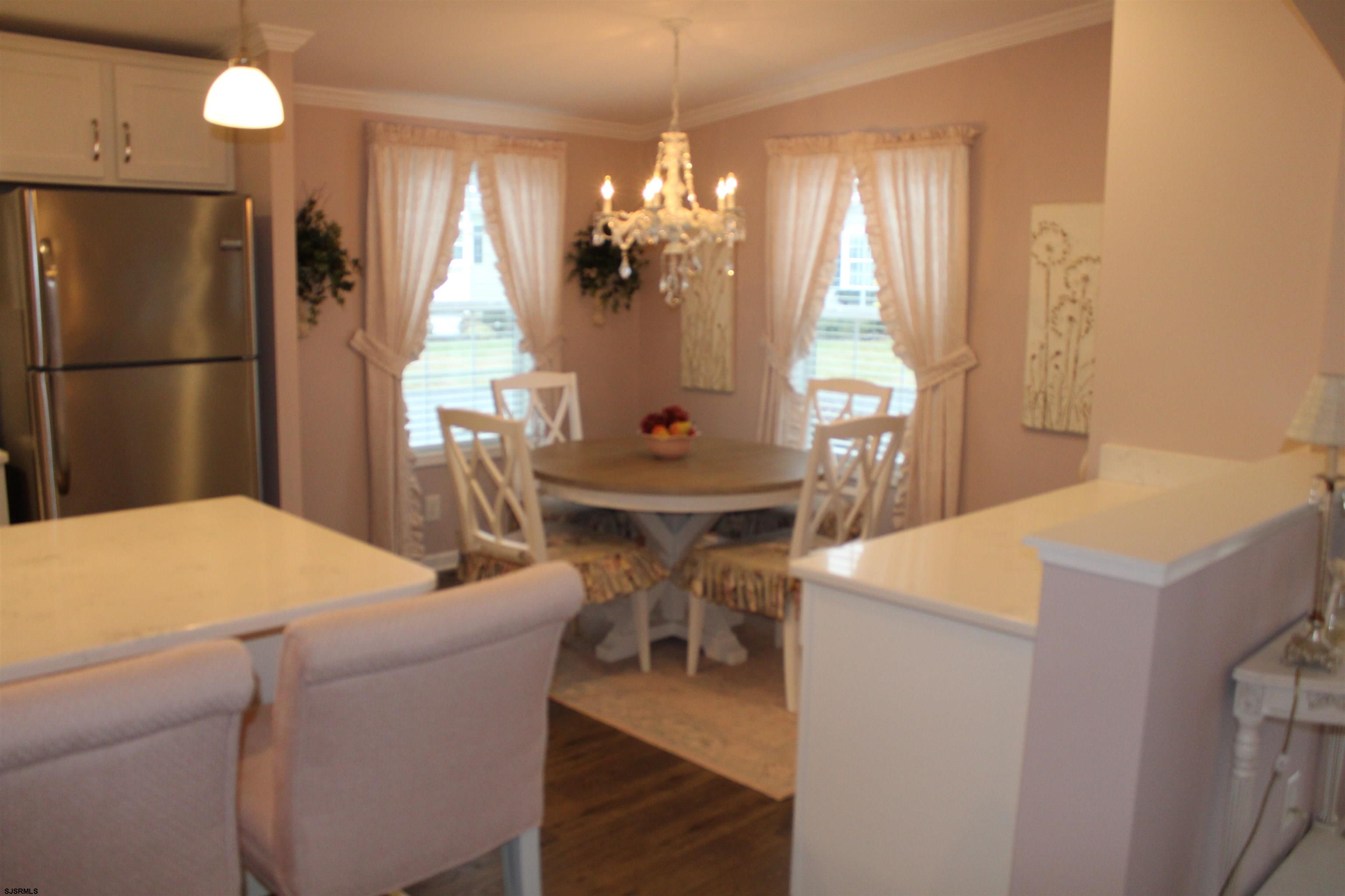 2058 South Shore Road, Unit 210 Ocean View, NJ 08230 - Photo 5 of 17 a dining room with chandelier and wooden floor