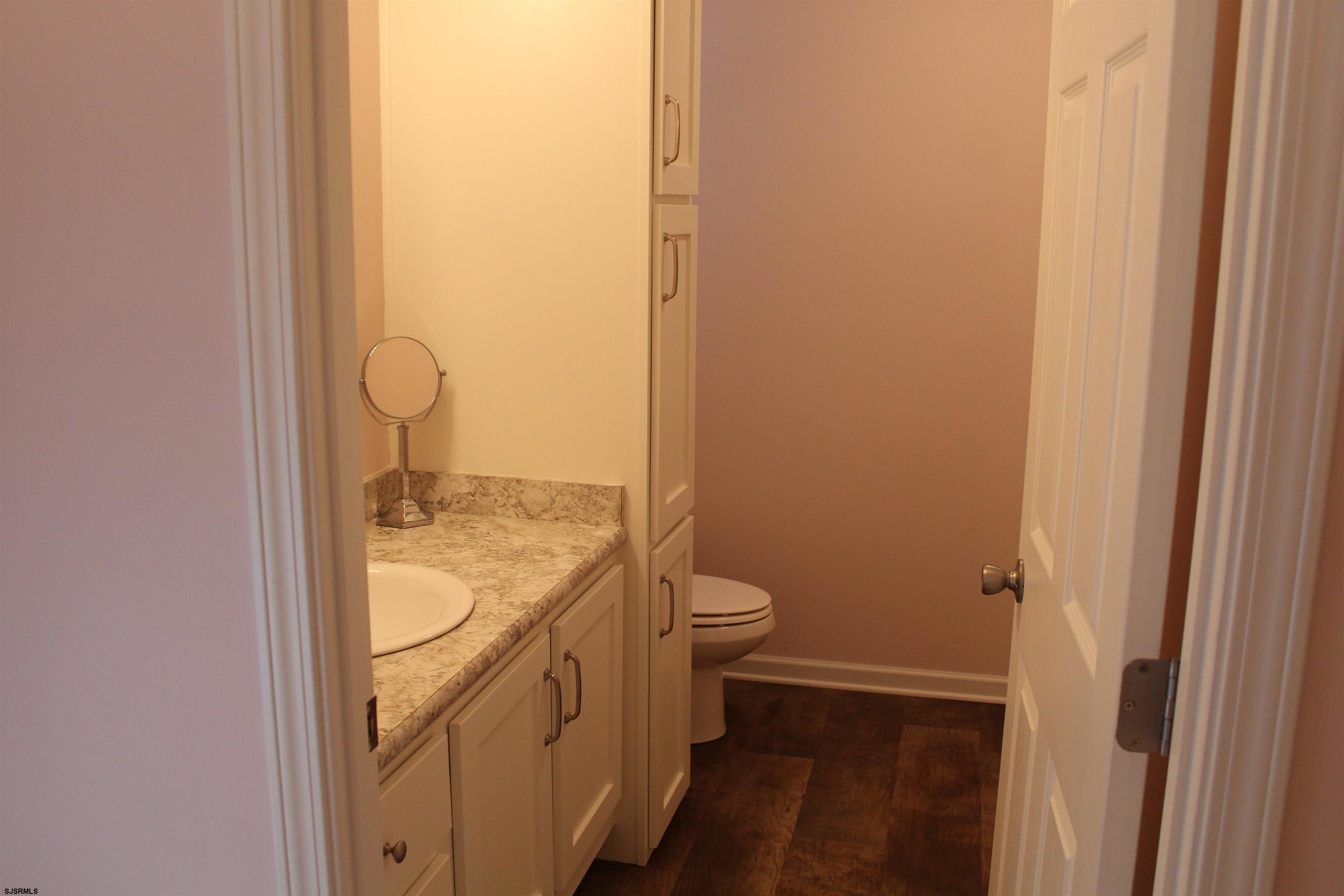 2058 South Shore Road, Unit 210 Ocean View, NJ 08230 - Photo 9 of 17 a bathroom with a granite countertop toilet and a sink