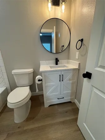 a bathroom with a toilet a sink and mirror