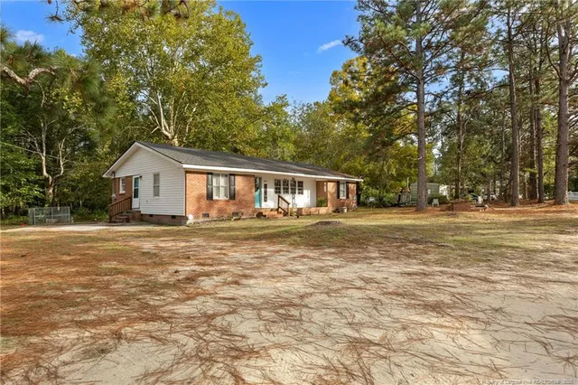 a front view of house with yard and trees around
