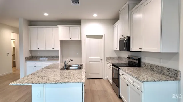 a kitchen with stainless steel appliances granite countertop a sink stove and refrigerator