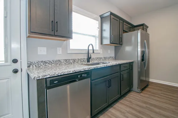 a kitchen with stainless steel appliances granite countertop a sink stove and refrigerator