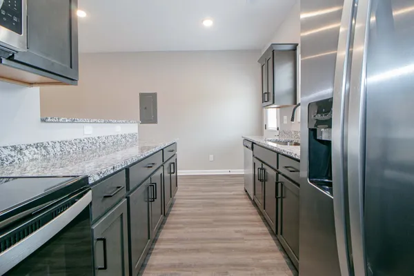a kitchen with granite countertop a sink and stove