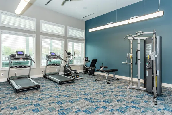 a living room with furniture a window and gym equipment