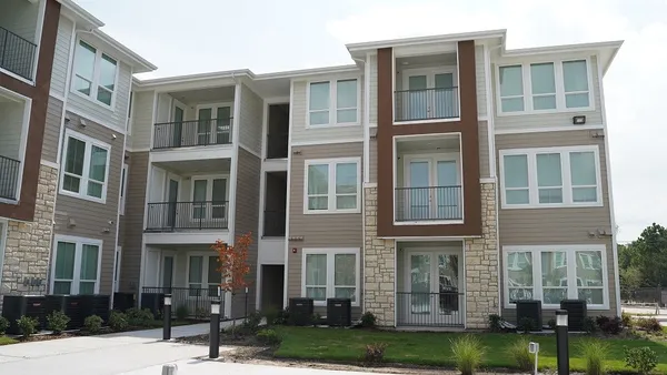 a front view of a residential apartment building with a yard