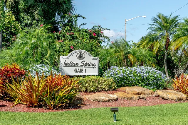 a view of a sign in a yard with potted plants