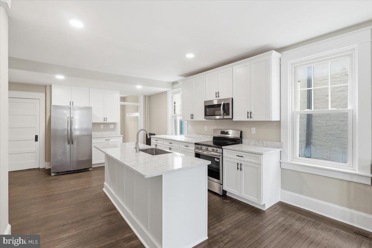 628 Trail Avenue Frederick, MD 21701 - Photo 7 of 37 a kitchen with stainless steel appliances granite countertop a stove top oven a refrigerator a sink and dishwasher with wooden floor