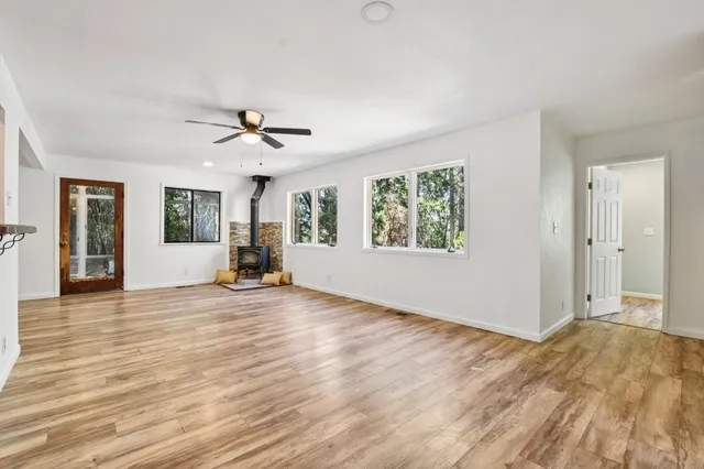 a view of a room with wooden floor and a ceiling fan