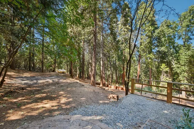 an empty room with wooden floor ceiling fan and windows