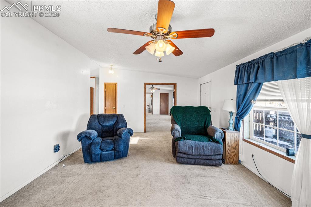 8435 Savage Road Beulah, CO 81023 - Photo 11 of 34 a living room with couches chandelier furniture and a large window
