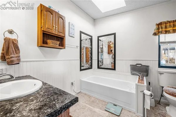a bathroom with a tub a sink and a mirror